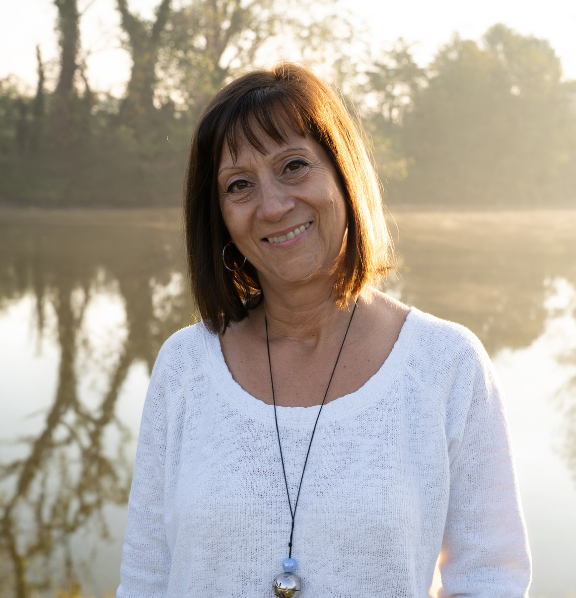 Paola Giussani sorridente in riva a un lago